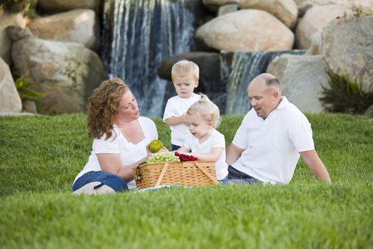 Happy Adorable Young Family with Twins Enjoy a Picnic in the Park.