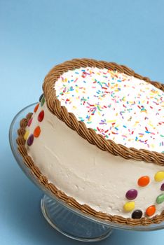 A decorated cake rests on a blue background to celebrate many occasions.