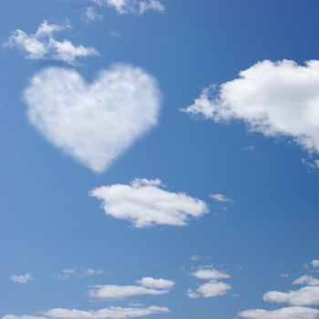 An open blue sky with a heart shaped in the clouds.