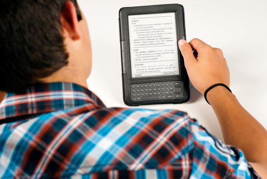 Teenage student in full concentration using an e-book