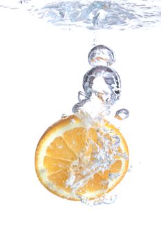 Orange falls into water on a white background