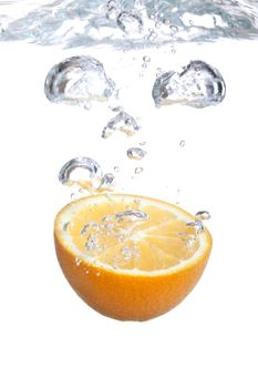 Orange falls into water on a white background