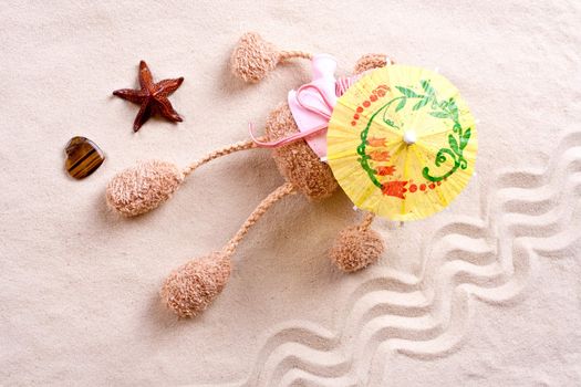 plush toy under the beach umbrella on the sand