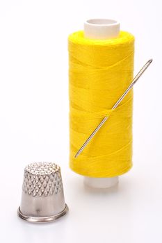 spool of thread for sewing with needle and thimble