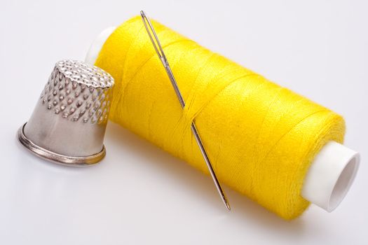 spool of thread for sewing with needle and thimble 