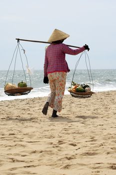 The Asian woman selling fruits on seacoast