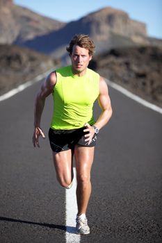 Running man athlete on road outdoors. Fit fitness runner man running and sweating in beautiful rough landscape. Full body image of young muscular Caucasian man.