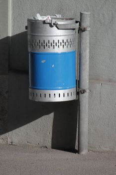 Outdoor blue and grey metallic dustbin in the street