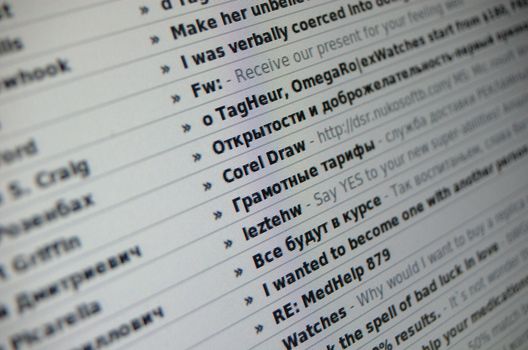 Close-up shot of a list of spam emails, on a computer display, with short depth of field. The center of focus is on the beginnings of the subject lines. Subjects are in both English and Russian. Could be used for any article relating to email, spam, or computer security.