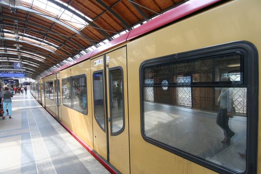 Berlin subway platform with passengers reflection