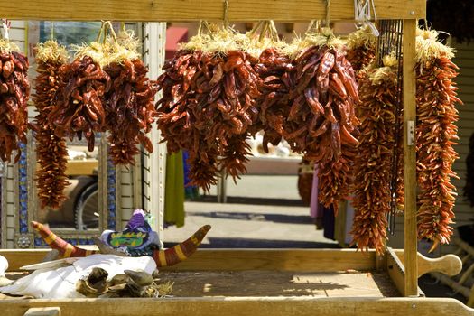 RED CHILE PEPPERS HANGING ON STORE FRONT CHIMAYO, NEW MEXICO
