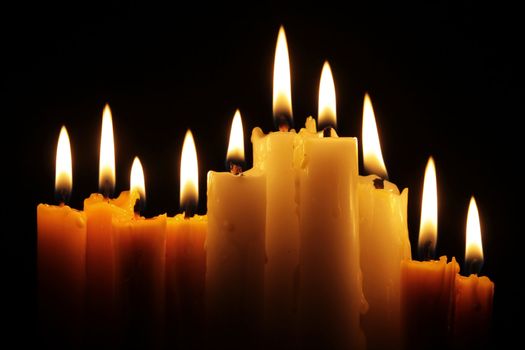 line of burning candles in the dark