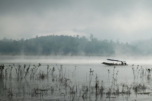 A man rowing his boat in river at Sangkhlaburi, thailand