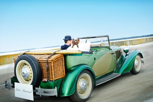 the newly married couple drive retro wedding car