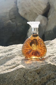 A bottle of cognac on the sandy beach.