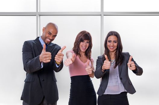 Happy multiracial business team going thumbs up.
