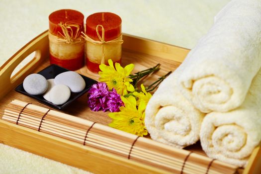 Still life on the spa. A tray of towels, candles and pebbles