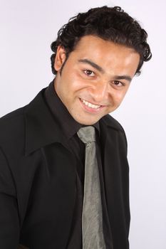 A young Indian businessman in a happy mood, on white studio background.