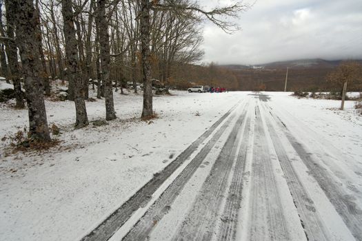 tyre tracks leadiing to 4X4 and group of people