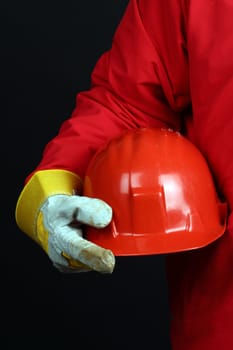 man holding red helmet over black background