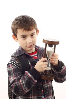 Portrait of a schoolboy with hour-glass. Time to school concept 