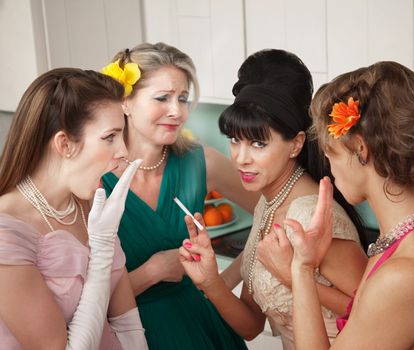 Four Caucasian women gossiping in a kitchen 