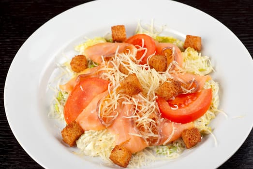 Salad of lettuce, chinese cabbage, tomato, garlic rusk, parmesan cheese, sauce and smoked salmon filet