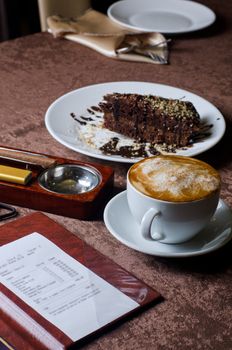 check, ashtray, cigar, lighter and coffee at restaurant table