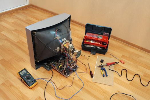 Repair of old TV at home on the floor of helper tools.