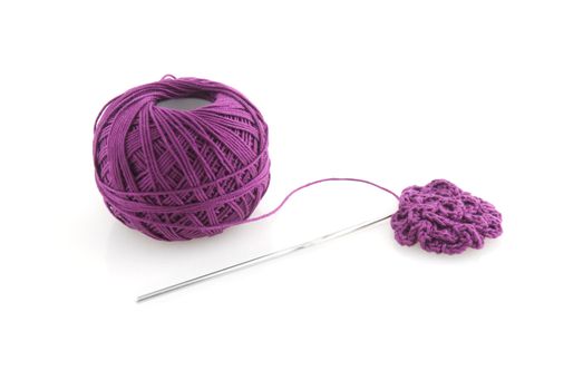 Purple spool and needle on a white background.