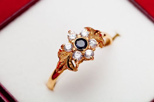 Fantastic gold ring adorned with one blue  and several white zirconia