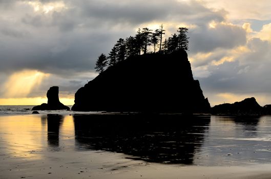 Silhouette of Sea Stack at Second Beach. A shaft of light breaks through the clouds.