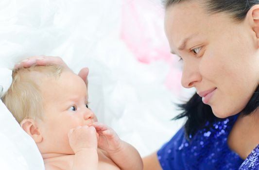 Mom with her little daughter lying in the bed