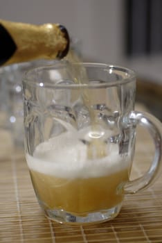 isolated shot of beer poured in a glass from a bottle