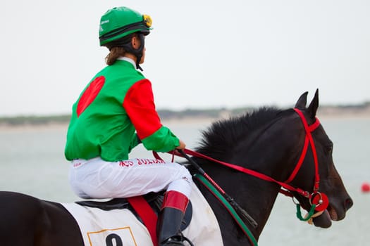 SANLUCAR DE BARRAMEDA, CADIZ, SPAIN - AUGUST 07: Horses races on August 07, 2010 on the beach of Sanlucar de Barrameda, Cadiz, Spain. The races of Sanlucar de Barrameda  are one of the most important horses races of the world