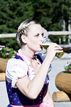 Bavarian woman in the beer garden with a glass of beer