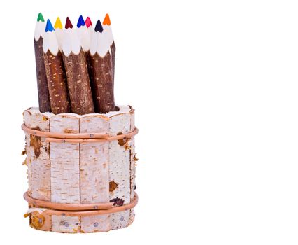 coloured pencils made from tree branches in a wooden holder 