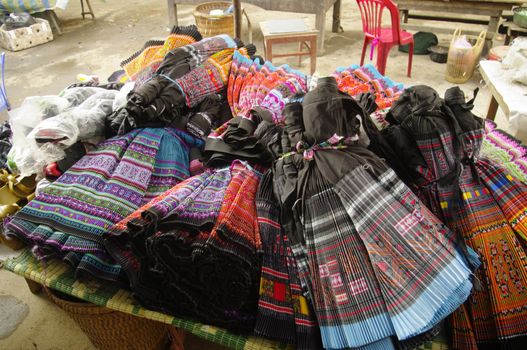 In Sin Ho market, where stall sells the dresses of the ethnic Hmong flower often produced in China today.