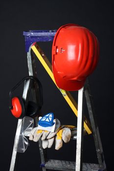 Safety gear kit on step ladder over black