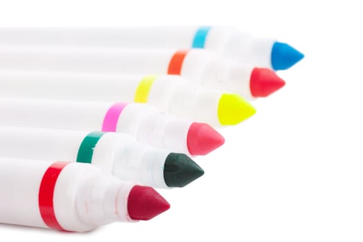 Six colorful markers over white background