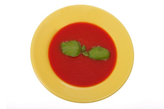 tomato soup in yellow plate, photo on white