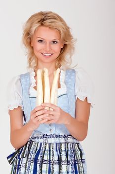 Beauty in Bavarian costume with asparagus in her hand