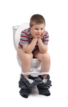 Little boy is sitting on the toilet 
