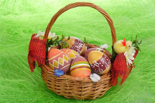 Easter eggs in basket on green Grass