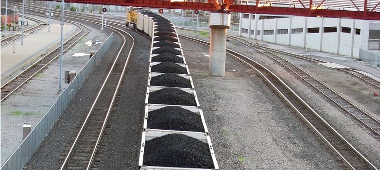 Train carrying coal through a town in the Midwest America.
