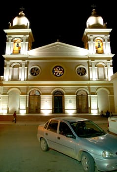 Car parking in front of illuminated Salta cathedral at night