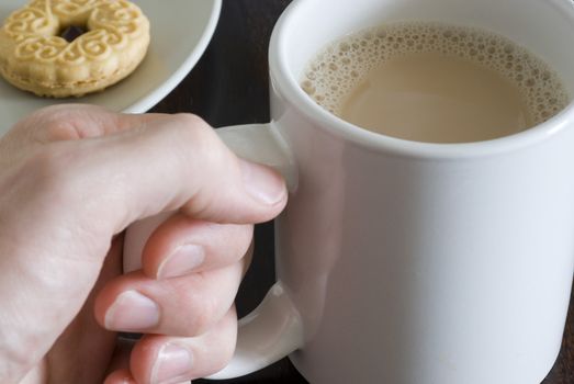 a large mug of white tea and biscuits