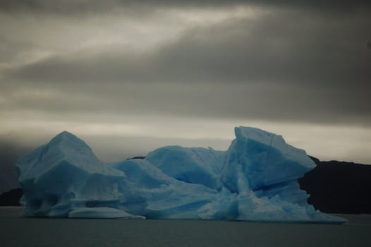 Dark grey clouds over blue ice block in southern Patagonia