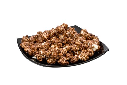 chocolate popcorn on the black plate isolated on white