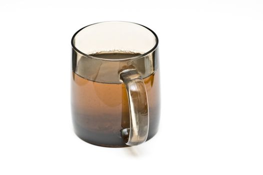 a transparent black cup with tea and tealeafs